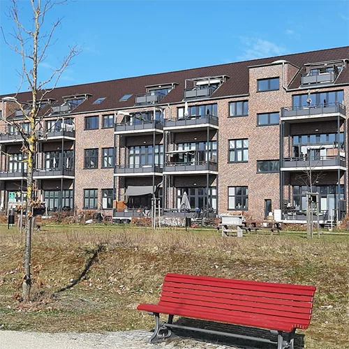 Mehrgeschossige Wohngebäude mit Balkonen und Sitzbank im Vordergrund in ruhiger Wohnlage
